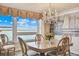 Elegant dining room featuring a chandelier, stylish furnishings, and panoramic water views at 634 Edgewater Dr # 744, Dunedin, FL 34698