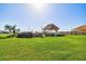 Inviting gazebo with a thatched roof nestled on a green lawn with water views at 634 Edgewater Dr # 744, Dunedin, FL 34698