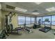 Well-equipped gym with various exercise machines and floor-to-ceiling windows overlooking the water at 634 Edgewater Dr # 744, Dunedin, FL 34698