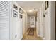 Hallway with neutral tile, framed art, and multiple doors leading to various rooms, creating flow at 634 Edgewater Dr # 744, Dunedin, FL 34698
