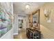 Inviting hallway featuring stylish wallpaper, decorative lamps, and a large mirror enhancing the sense of space at 634 Edgewater Dr # 744, Dunedin, FL 34698