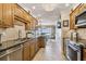 Well-equipped kitchen boasting wood cabinetry, granite counters, and stainless steel appliances at 634 Edgewater Dr # 744, Dunedin, FL 34698