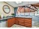 Kitchenette with granite counters, wood cabinets and view to large ballroom with vaulted ceiling at 634 Edgewater Dr # 744, Dunedin, FL 34698
