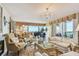 Elegant living room with a chandelier, comfortable seating, and a grand piano offering stunning views at 634 Edgewater Dr # 744, Dunedin, FL 34698