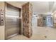 Condo lobby featuring tiled floors, stone accents, elevator access, and mailboxes at 634 Edgewater Dr # 744, Dunedin, FL 34698