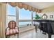 Bright piano room featuring water views, a piano, and comfortable seating at 634 Edgewater Dr # 744, Dunedin, FL 34698