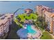 Aerial view of the community pool surrounded by condos, manicured lawns, and waterfront views at 634 Edgewater Dr # 744, Dunedin, FL 34698