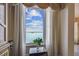 Scenic view from the home overlooking blue skies and waters with lush greenery visible, framed by elegant drapes at 634 Edgewater Dr # 744, Dunedin, FL 34698