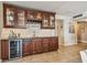 Stylish wet bar featuring custom cabinetry, wine storage, granite countertops, and elegant tile backsplash at 634 Edgewater Dr # 744, Dunedin, FL 34698