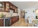 Wet bar featuring granite countertops, wooden cabinets, wine fridge, and decorative backsplash at 634 Edgewater Dr # 744, Dunedin, FL 34698