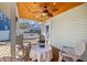 Cozy back porch featuring a wood ceiling, ceiling fan, and outdoor seating around a table with a porch swing in background at 6603 N Branch Ave, Tampa, FL 33604