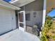 Screened front porch area with tile flooring and chair at 823 La Jolla Ave, Sun City Center, FL 33573