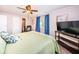 Comfortable bedroom featuring ceiling fan, television, and an ensuite bathroom at 826 Paradise Blvd, Tarpon Springs, FL 34689