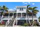 Exterior shows two-story columned porch, screened-in lanai, and mature landscaping and palms at 829 Blue Heron Blvd, Ruskin, FL 33570