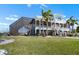Rear exterior shows a large screened-in lanai, manicured lawn, colorful landscaping, and second-story porch at 829 Blue Heron Blvd, Ruskin, FL 33570