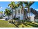 Exterior shows two-story columned porch, screened-in lanai, landscaping, and mature palm trees at 829 Blue Heron Blvd, Ruskin, FL 33570