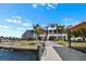 Waterfront home features a private dock, screened-in lanai, lush landscaping, and two stories of outdoor living space at 829 Blue Heron Blvd, Ruskin, FL 33570