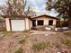 Single-story home undergoing renovation with a detached garage and a yard needing landscaping at 9255 82Nd Way, Seminole, FL 33777