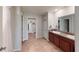 Bathroom with double vanity, tiled floors, and an open doorway leading to the walk-in closet at 10115 Paradise Fish Dr, Riverview, FL 33578