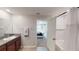 Bathroom with a granite-topped vanity, tile floor, and shower/tub combo next to the primary bedroom at 10115 Paradise Fish Dr, Riverview, FL 33578