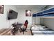 Modern bedroom with a bunk bed, workstation, and large TV, perfect for study and relaxation at 10115 Paradise Fish Dr, Riverview, FL 33578