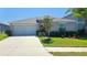 Charming single-story home featuring a two car garage, well-maintained lawn, and a beautifully landscaped front yard at 10115 Paradise Fish Dr, Riverview, FL 33578