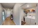 Hallway featuring neutral paint, tile floors, a console table, and a laundry room entrance with a white washer and dryer at 10115 Paradise Fish Dr, Riverview, FL 33578