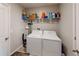 Functional laundry room with a white washer, dryer, and shelving for ample storage, complemented by neutral paint at 10115 Paradise Fish Dr, Riverview, FL 33578