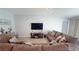 Cozy living room featuring a comfortable sofa, entertainment center, and neutral color scheme, perfect for relaxation at 10115 Paradise Fish Dr, Riverview, FL 33578