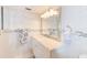 Bright bathroom featuring white tile, granite vanity, and decorative starfish accents at 10215 Regal Dr # 45, Largo, FL 33774