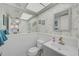Cozy bathroom featuring leaf-patterned wallpaper, white wainscoting, and a mirrored wall at 10215 Regal Dr # 45, Largo, FL 33774