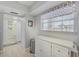 Hallway with white cabinets, a window view, and access to the bathroom at 10215 Regal Dr # 45, Largo, FL 33774