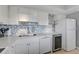Bright kitchen featuring white cabinetry, a stylish backsplash, and modern appliances at 10215 Regal Dr # 45, Largo, FL 33774