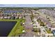 Aerial view of a neighborhood with a community lake, showcasing rows of houses and well-maintained streets at 10222 Newminster Loop, Ruskin, FL 33573