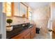 Bathroom featuring granite countertop, sleek black toilet, and decorative wallpaper at 11601 86Th Ave, Seminole, FL 33772