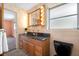Bathroom with granite countertop, black toilet, and light sconces around the mirror at 11601 86Th Ave, Seminole, FL 33772