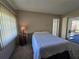Bedroom with carpet, side table, and a sliding door leading to the outside, with blinds for privacy at 11601 86Th Ave, Seminole, FL 33772