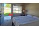 Bedroom features a bed, window view to the front yard, and access to the front door at 11601 86Th Ave, Seminole, FL 33772