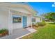 Stylish home entrance with a blue door, decorative columns, and lush landscaping for an inviting appeal at 11601 86Th Ave, Seminole, FL 33772