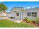 Close-up of a home's entrance featuring a stylish blue door, decorative pillars, and manicured landscaping at 11601 86Th Ave, Seminole, FL 33772