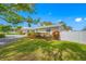 Beautifully landscaped yard of a well-maintained home, showcasing lush greenery and a white picket fence at 11601 86Th Ave, Seminole, FL 33772