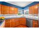 Beautiful kitchen featuring wooden cabinets, granite counters, and stainless dishwasher with natural light at 11601 86Th Ave, Seminole, FL 33772