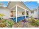 Covered patio with blue carpet, a glass top table and white chairs with a lush rock garden at 11601 86Th Ave, Seminole, FL 33772