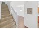Carpeted staircase and hardwood flooring lead to the upper and lower levels of the home at 1256 Redondo Way, Wesley Chapel, FL 33543