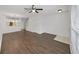 Spacious living room with wood-look flooring, ceiling fan, and an open layout that flows into the kitchen at 1256 Redondo Way, Wesley Chapel, FL 33543