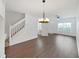 Well-lit living area featuring wood-look floors, stairs, and an elegant chandelier, creating a warm and inviting atmosphere at 1256 Redondo Way, Wesley Chapel, FL 33543