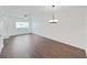 Open concept living room with wood-look floors, ceiling fan and chandelier, and natural light at 1256 Redondo Way, Wesley Chapel, FL 33543