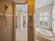 Tiled bathroom with walk in shower and a garden tub at 12733 Grand Traverse Dr, Dade City, FL 33525