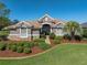 Charming single-story home with lush landscaping, a tiled roof, and a well-manicured lawn at 12733 Grand Traverse Dr, Dade City, FL 33525