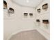 Walk-in closet with ample storage space, featuring multiple shelves and neutral carpeting at 12766 Jade Empress Loop # 202, Venice, FL 34293